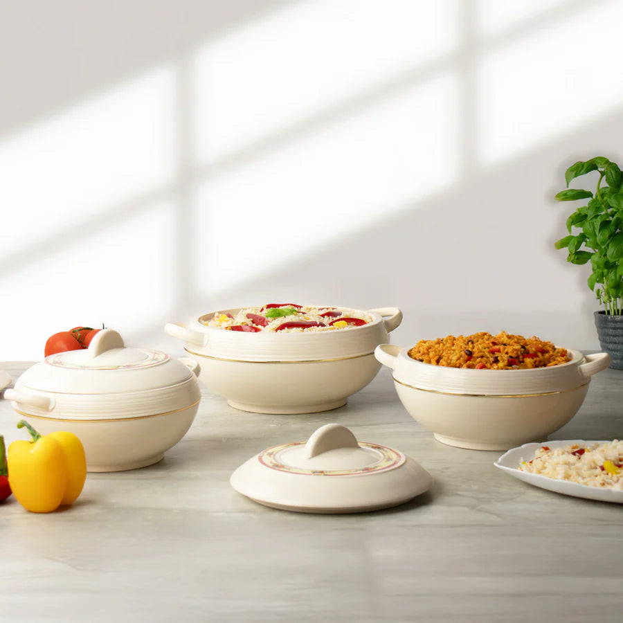 Set of ceramic pots with lids on a light wooden surface, with food and vegetables around.