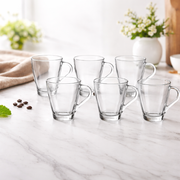 Set of clear glass mugs on a marble surface with a light background
