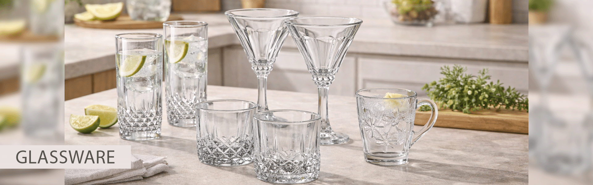 Set of glassware including tumblers and a mug on a wooden surface with a blurred background.